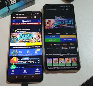 Two smartphones are displayed on a white surface, both showing gambling websites with colorful graphics, text, and various options for logging in and accessing games. The screens are bright and filled with promotional content related to casino and slot games.